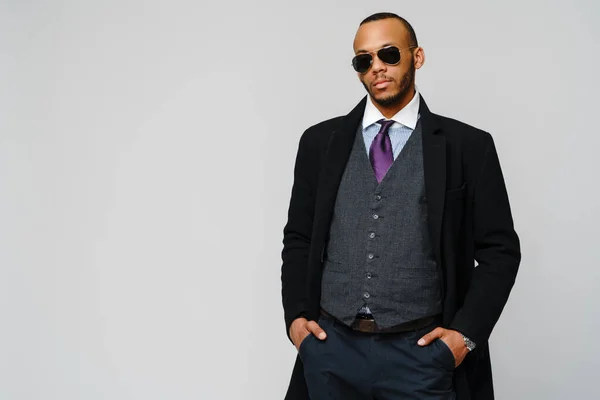 Estúdio de um empresário afro-americano vestindo casaco sobre fundo cinza claro — Fotografia de Stock