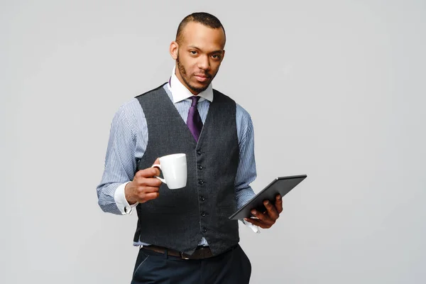 Hombre de negocios afroamericano profesional sosteniendo la tableta PC y taza de café —  Fotos de Stock