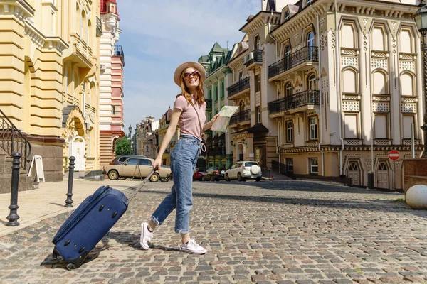 Mooie Jonge Vrouw toerist Aangenaam met plattegrond en koffer in het stadscentrum — Stockfoto