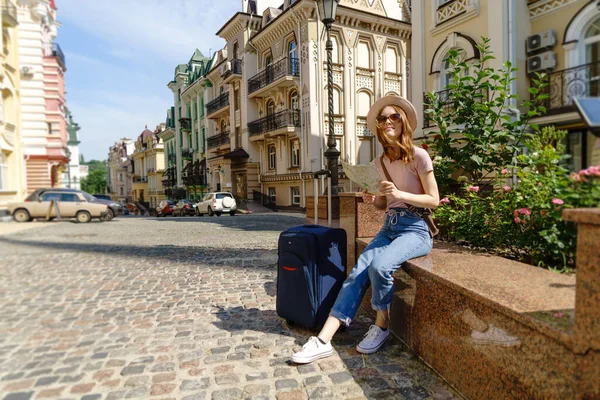 Bella Giovane Donna turistica Piacevole con mappa della città e valigia nel centro della città — Foto Stock