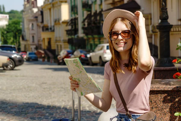 Hermosa joven turista Agradable con mapa de la ciudad y maleta en el centro de la ciudad — Foto de Stock