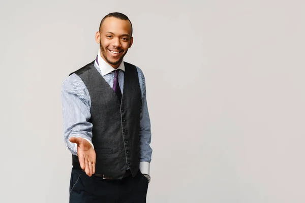 Knap Afrikaans-Amerikaanse zakenman handdruk gebaar over licht grijze achtergrond — Stockfoto