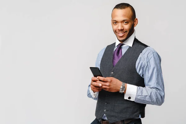 Hombre de negocios afroamericano profesional sosteniendo teléfono móvil —  Fotos de Stock