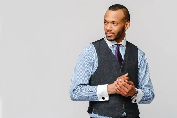 Studioaufnahme eines jungen afroamerikanischen Geschäftsmannes vor grauem Hintergrund — Stockfoto