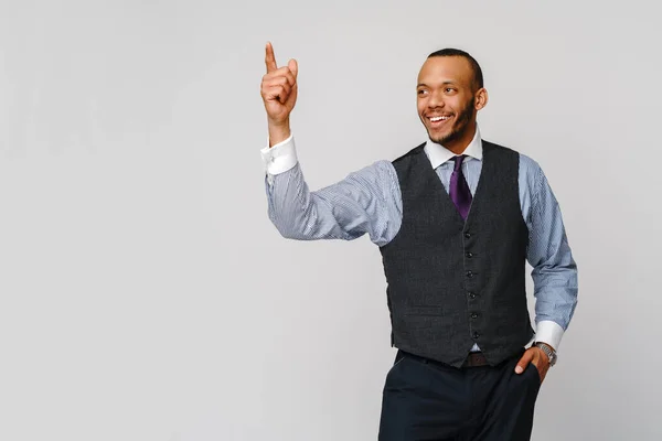 Hombre de negocios afroamericano que aparece con el dedo sobre fondo gris —  Fotos de Stock