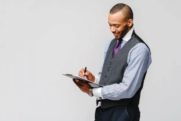 Un joven afroamericano sosteniendo una tableta de mesa y un bolígrafo —  Fotos de Stock
