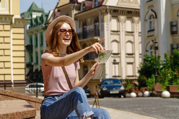 Schöne junge Frau Touristin Angenehm mit Stadtplan sitzt auf Treppen im Stadtzentrum — Stockfoto