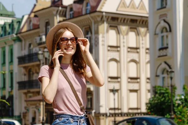 Smuk ung kvinde turist i byens centrum taler i telefon - Stock-foto