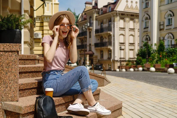 Bella giovane donna turista con caffè da asporto seduto sulle scale — Foto Stock