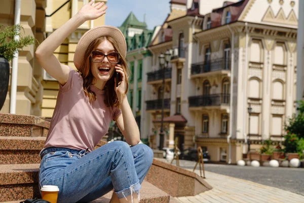 Bella giovane donna turista con caffè da asporto seduto sulle scale utilizzando smartphone — Foto Stock