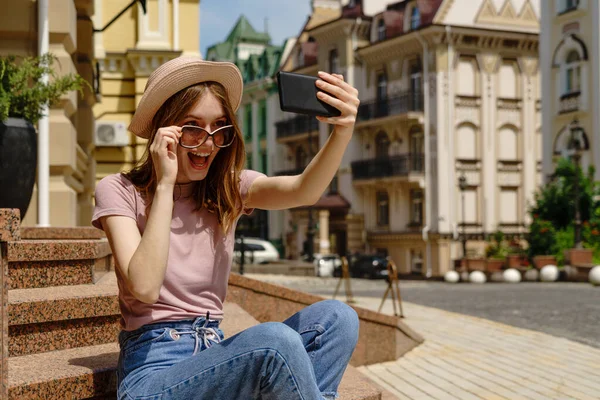 Bella giovane donna turista seduto sulle scale utilizzando smartphone fare videochiamate o selfie — Foto Stock