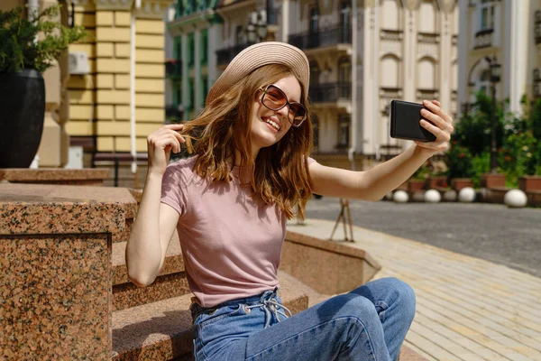 Bella giovane donna turista seduto sulle scale utilizzando smartphone fare videochiamate o selfie — Foto Stock