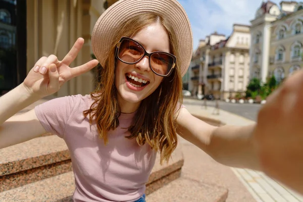 Ładna młoda kobieta w okularach robi selfie w centrum miasta — Zdjęcie stockowe