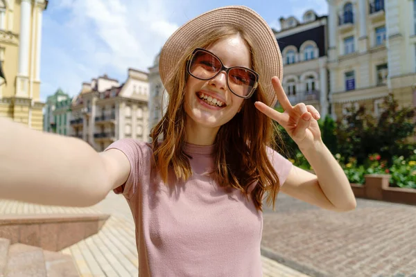 Mujer bastante joven en gafas haciendo selfie en el centro de la ciudad —  Fotos de Stock