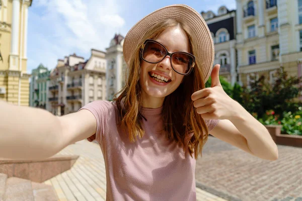 Mujer bastante joven en gafas haciendo selfie en el centro de la ciudad —  Fotos de Stock