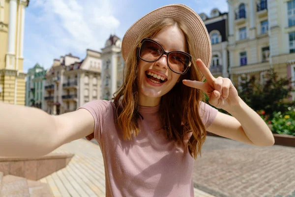 Ładna młoda kobieta w okularach robi selfie w centrum miasta — Zdjęcie stockowe