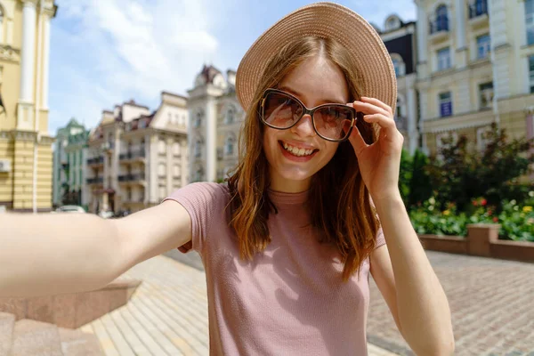 Bella giovane donna in occhiali fare selfie al centro della città — Foto Stock