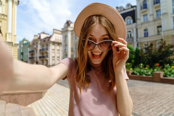 Красива молода жінка в окулярах робить селфі в центрі міста — стокове фото