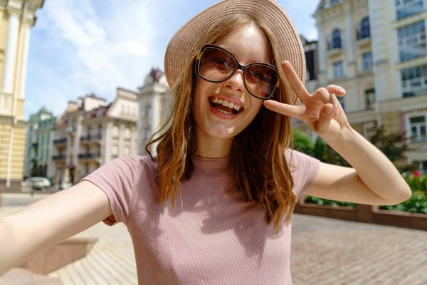 Ładna młoda kobieta w okularach robi selfie w centrum miasta — Zdjęcie stockowe