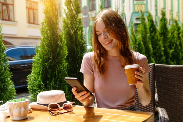 Giovane donna che parla al telefono in un caffè su una terrazza estiva — Foto Stock