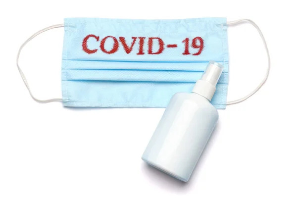 Frasco de loción, desinfectante o jabón líquido y mascarilla protectora médica con signo COVID-19 aislado sobre fondo blanco con camino de recorte —  Fotos de Stock