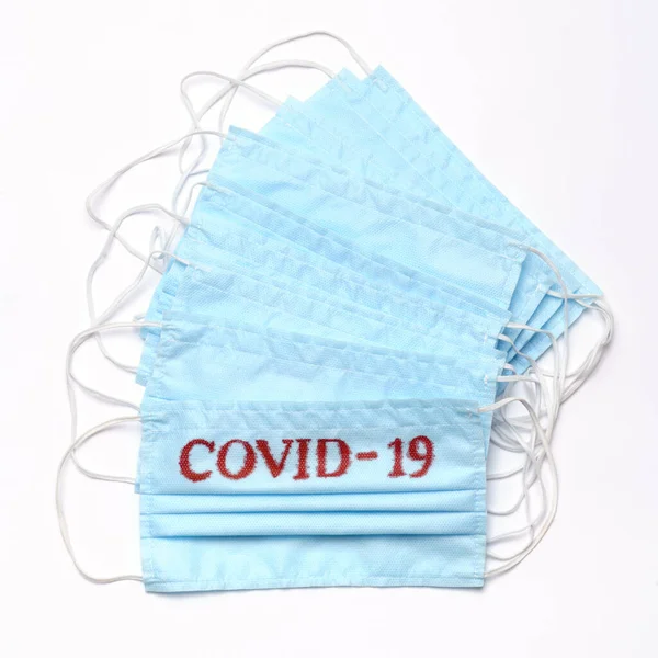 Coronavirus COVID-19 concepto pandémico - pila de antiviral máscara médica de protección quirúrgica con signo COVID-19 para la protección contra el virus de la corona —  Fotos de Stock