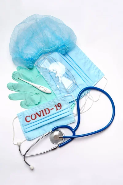 Coronavirus COVID-19 concetto di pandemia - pila di maschera medica protettiva chirurgica antivirale per la protezione contro il virus della corona, stetoscopio, occhiali e termometro elettronico — Foto Stock