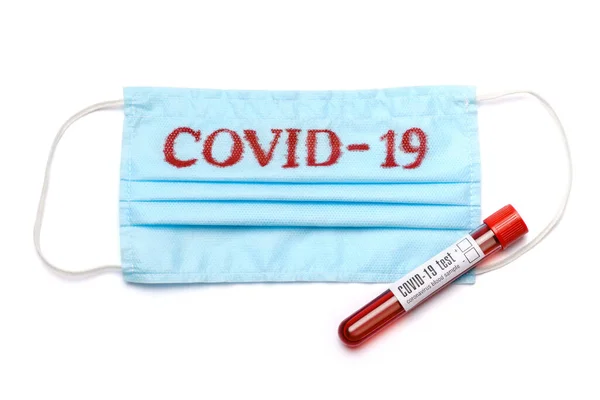 Tubo per analisi del sangue e maschera protettiva medica con segno COVID-19 isolato su sfondo bianco con percorso di ritaglio — Foto Stock