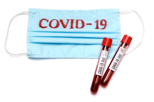 Трубка для анализа крови и медицинская защитная маска со знаком COVID-19 изолированы на белом фоне с вырезкой — стоковое фото