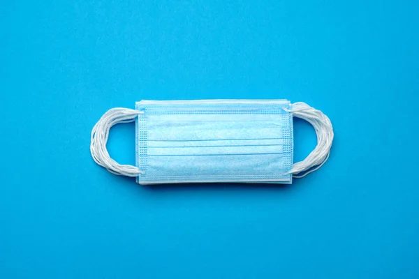 Stapel wegwerpbare blauwe medische gezichtsmaskers op blauwe achtergrond — Stockfoto