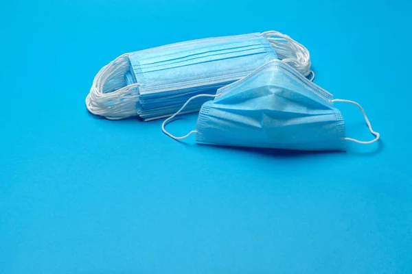 Stapel von blauen medizinischen Einwegmasken auf blauem Hintergrund — Stockfoto