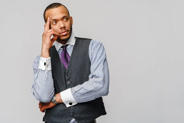 Empresário afro-americano toma decisões difíceis sobre fundo cinzento — Fotografia de Stock
