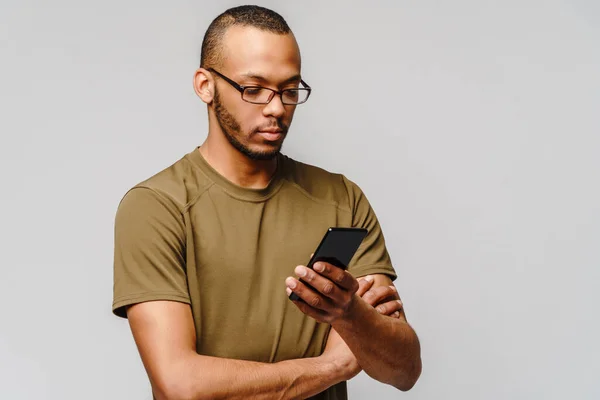 Ritratto di un giovane afroamericano con gli occhiali in mano cellulare — Foto Stock