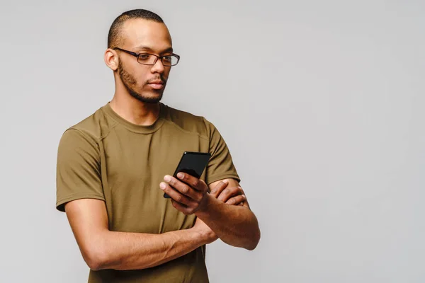 Ritratto di un giovane afroamericano con gli occhiali in mano cellulare — Foto Stock