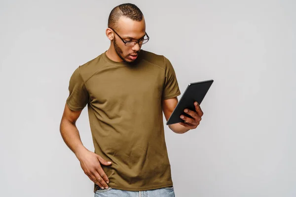 Ritratto di un giovane uomo afroamericano con gli occhiali in mano tablet pc pad — Foto Stock