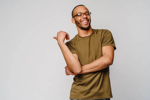 穿着绿色T恤的快乐的友好的非洲裔美国年轻人用手指指向复制的空间 — 图库照片