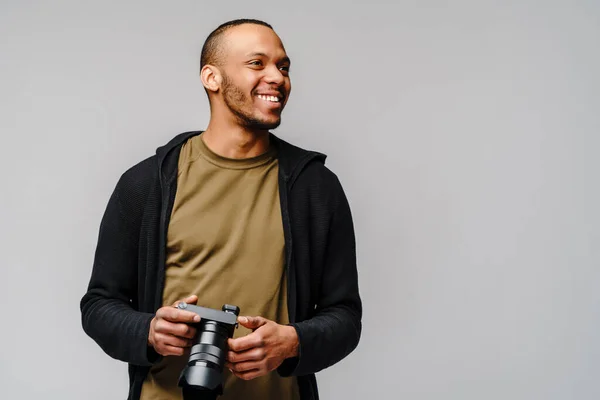 Bello afro americano ragazzo tenendo digitale fotocamera su luce grigio sfondo — Foto Stock
