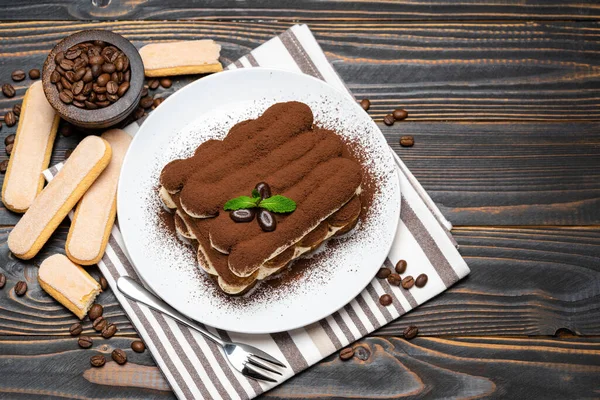 Klasik tiramisu tatlısı seramik tabakta ahşap arka planda — Stok fotoğraf