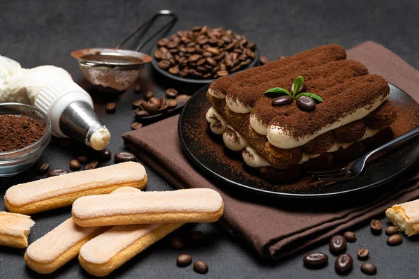 Klasyczny deser tiramisu i savoiardi ciasteczka na płycie ceramicznej na betonowym tle — Zdjęcie stockowe