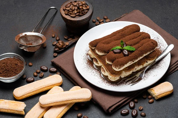 Klasik tiramisu tatlısı ve çimento arka planda seramik tabakta savoiardi kurabiyeleri. — Stok fotoğraf