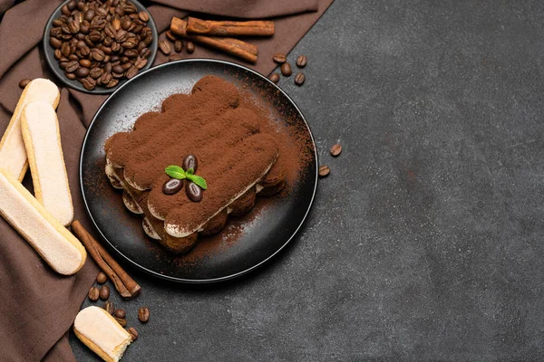 Klassisches Tiramisu-Dessert auf Keramikteller und savoiardi-Kekse auf Betongrund — Stockfoto