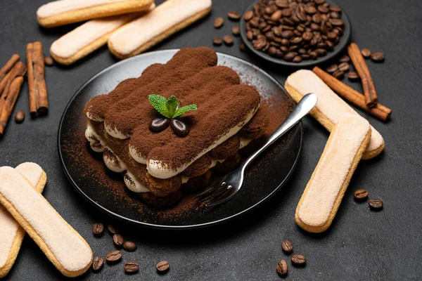 Dessert tiramisù classico su piatto di ceramica e biscotti savoiardi su fondo di cemento — Foto Stock