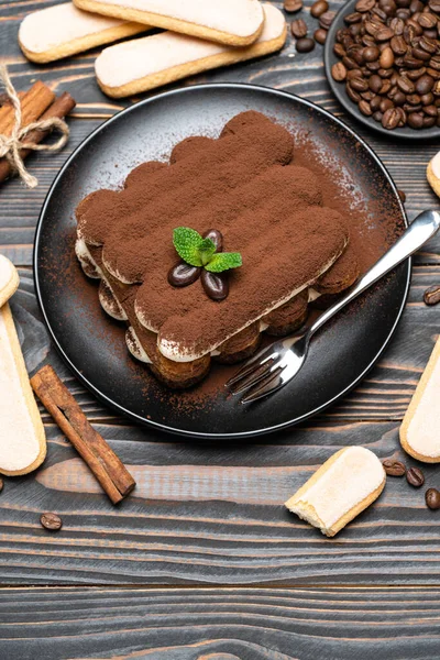 Классический десерт тирамису на керамической тарелке и печенье савойарди на деревянном фоне — стоковое фото