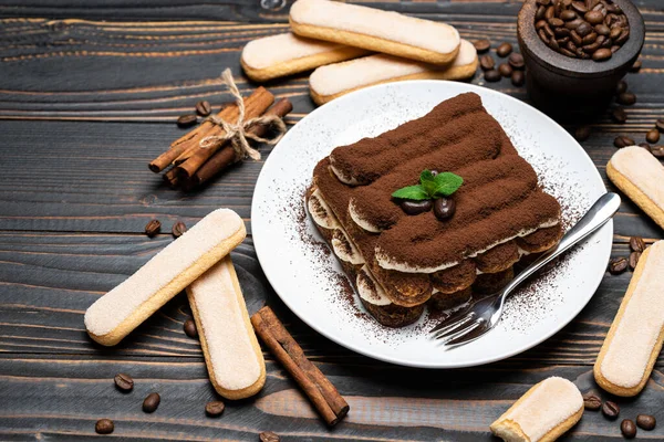 Seramik tabakta klasik tiramisu tatlısı ve ahşap zeminde savoiardi kurabiyesi. — Stok fotoğraf