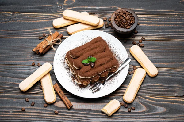 Postre tiramisú clásico sobre plato de cerámica y galletas savoiardi sobre fondo de madera — Foto de Stock