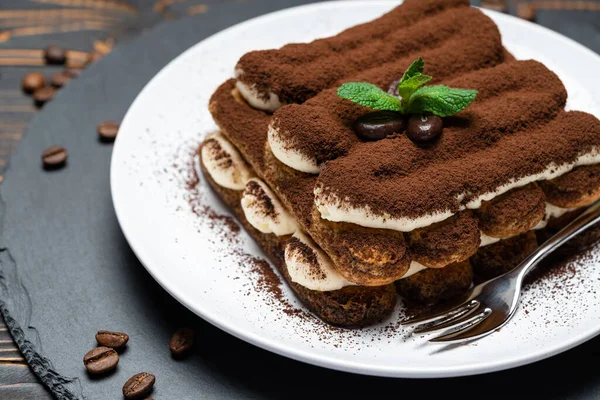 Classic tiramisu dessert on ceramic plate on wooden background — 스톡 사진