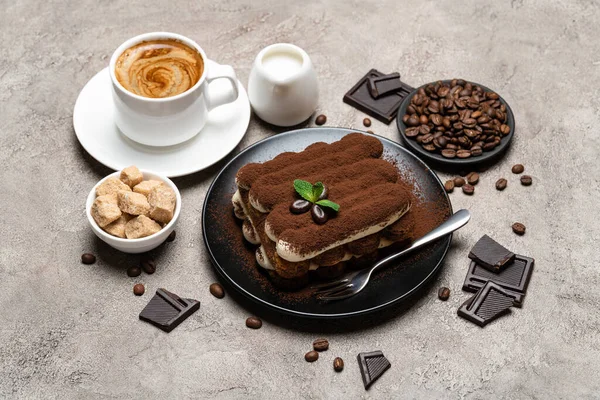 Klasyczny deser tiramisu, filiżanka kawy, cukier i mleko na konkretnym tle — Zdjęcie stockowe