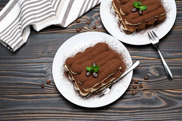 Dos porciones de postre tiramisú clásico en plato de cerámica sobre fondo de madera — Foto de Stock