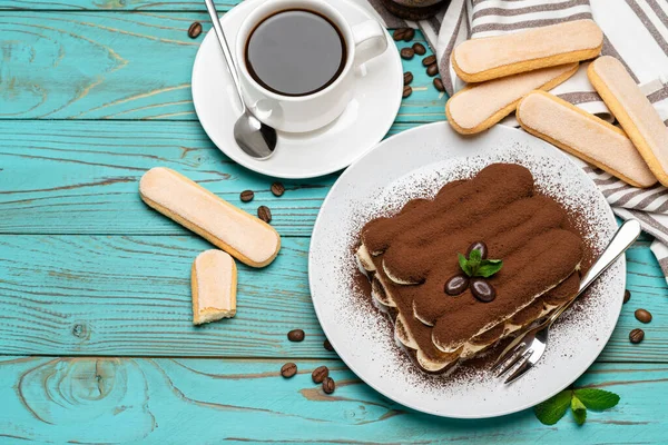 Часть классического десерта тирамису, чашка кофе и печенье савойарди на деревянном фоне — стоковое фото