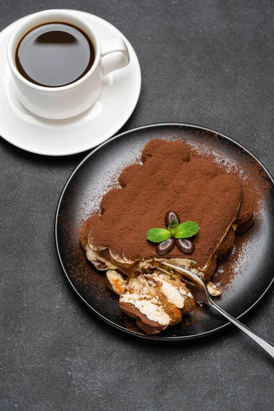 Portion klassisches Tiramisu-Dessert und Tasse frischen Espresso-Kaffees auf Betongrund — Stockfoto